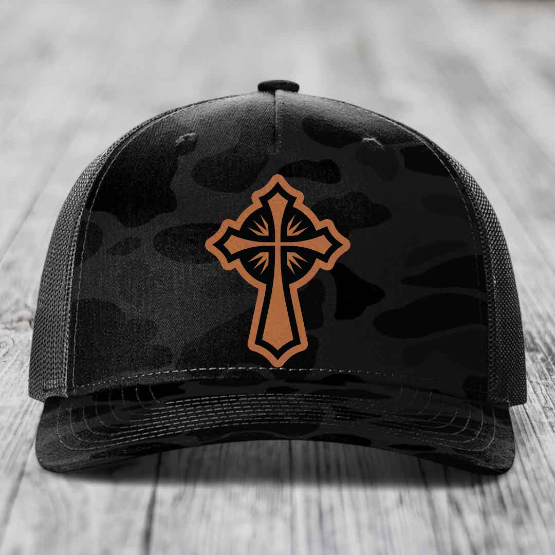 Black camouflage trucker hat with brown cross patch on front.