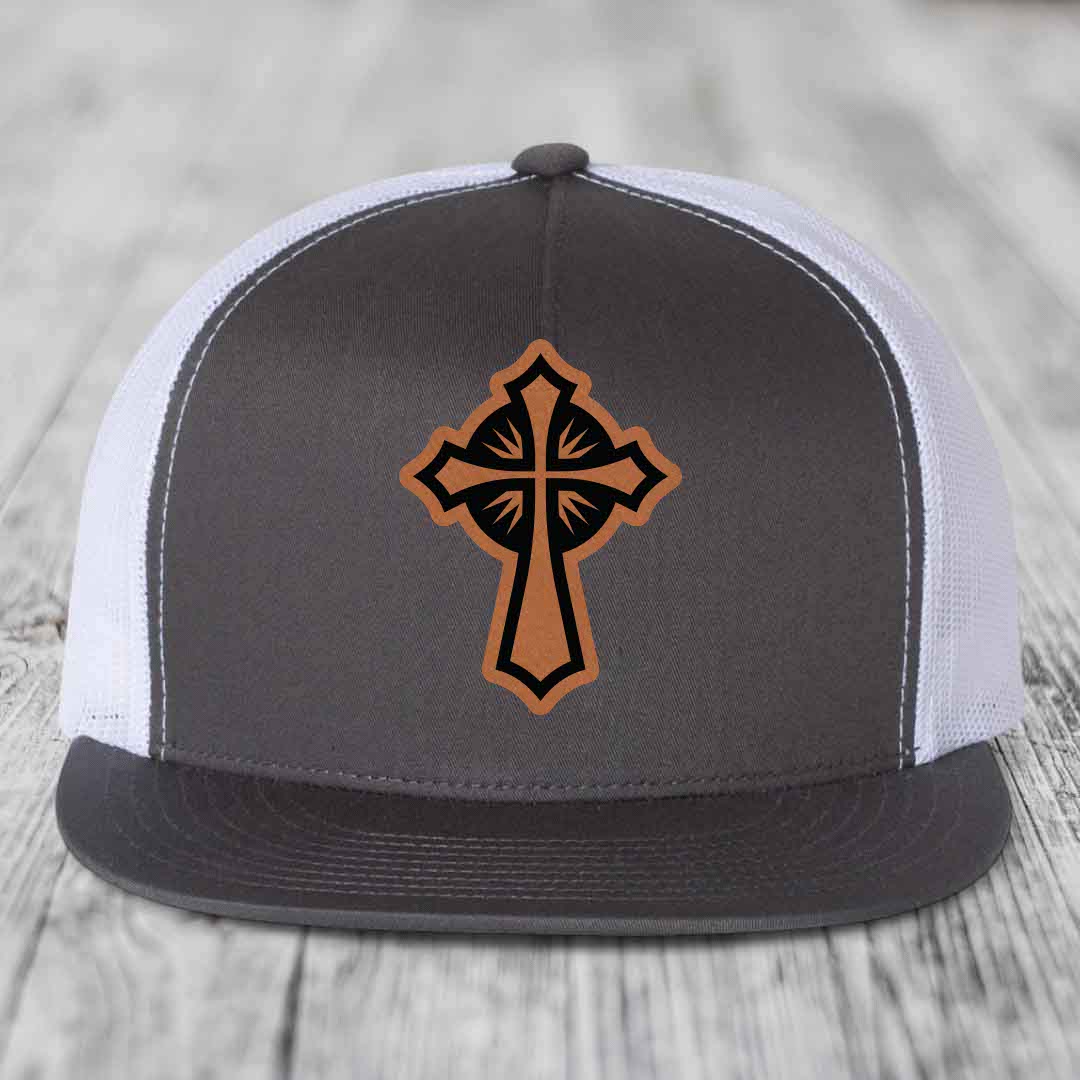 Grey trucker hat with brown and black cross leather patch on front.
