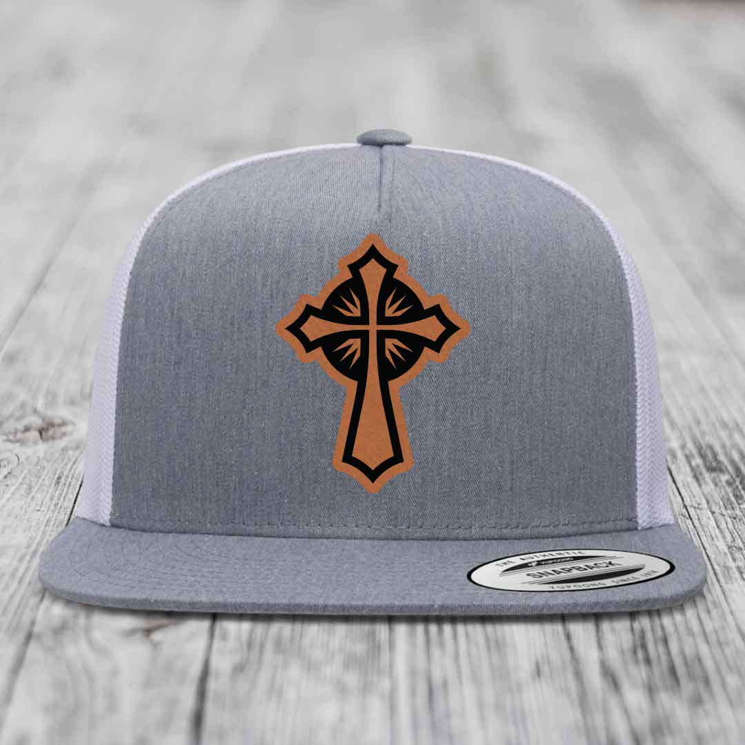 Grey trucker hat with brown and black cross leather patch on front.