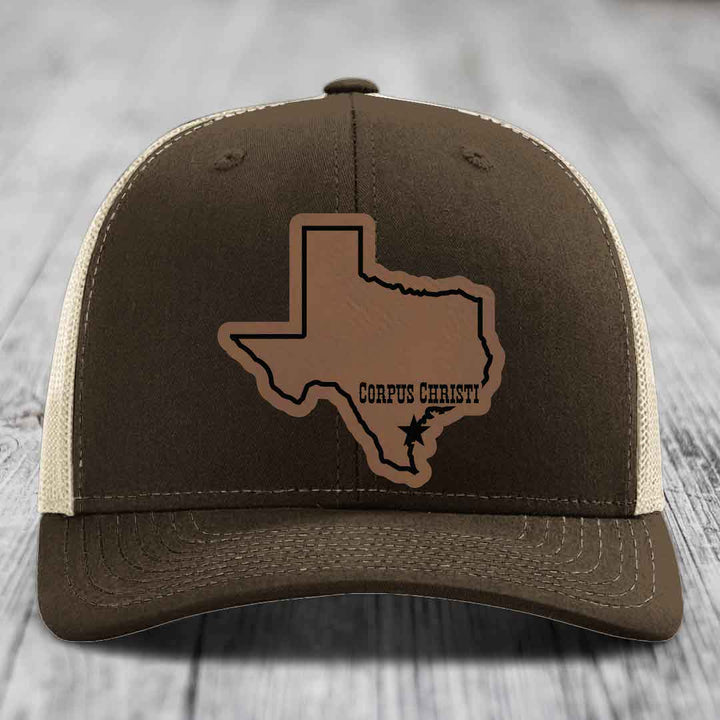 Green trucker hat with brown leather patch of Texas state outline and &