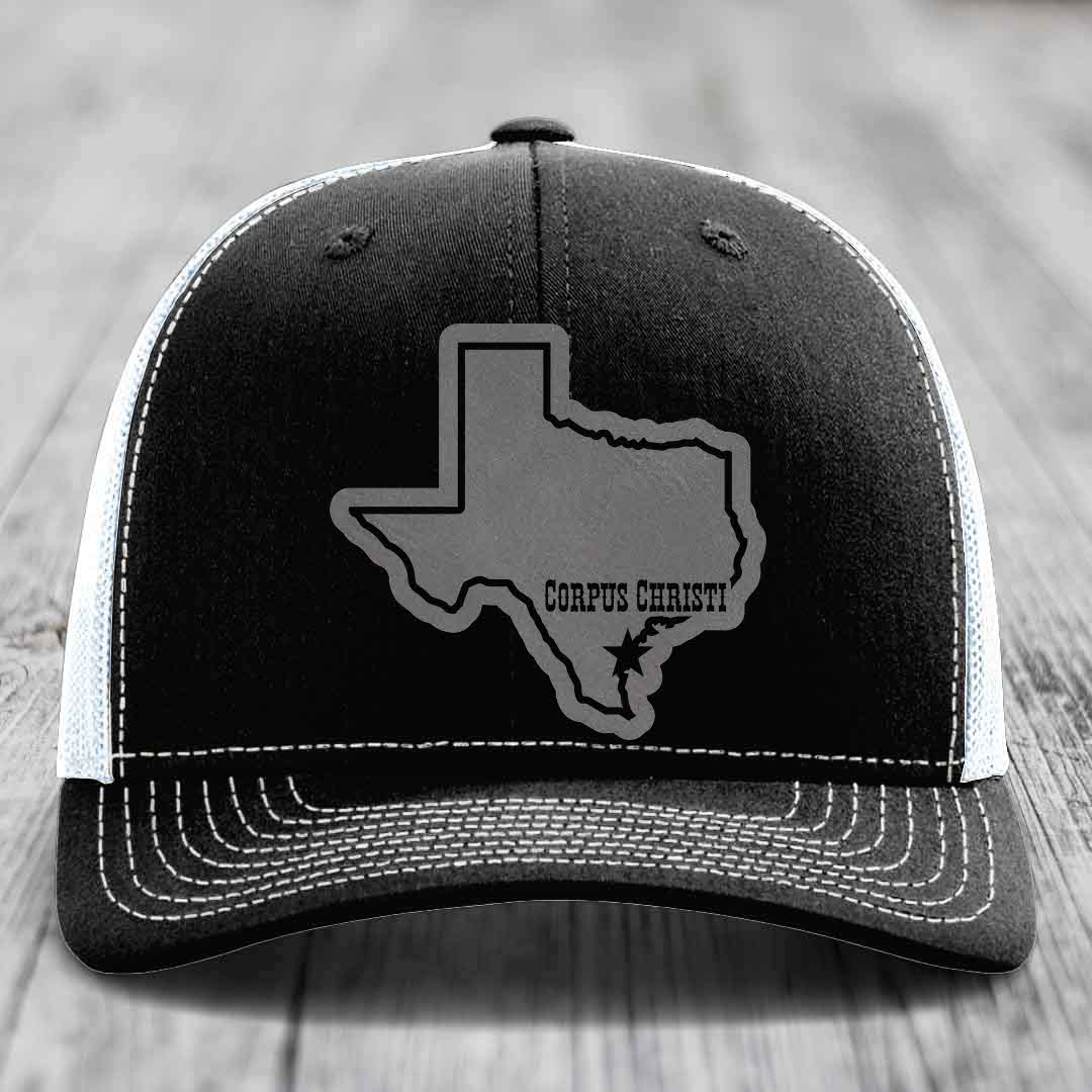 Black and white trucker hat with gray Texas outline patch reading &