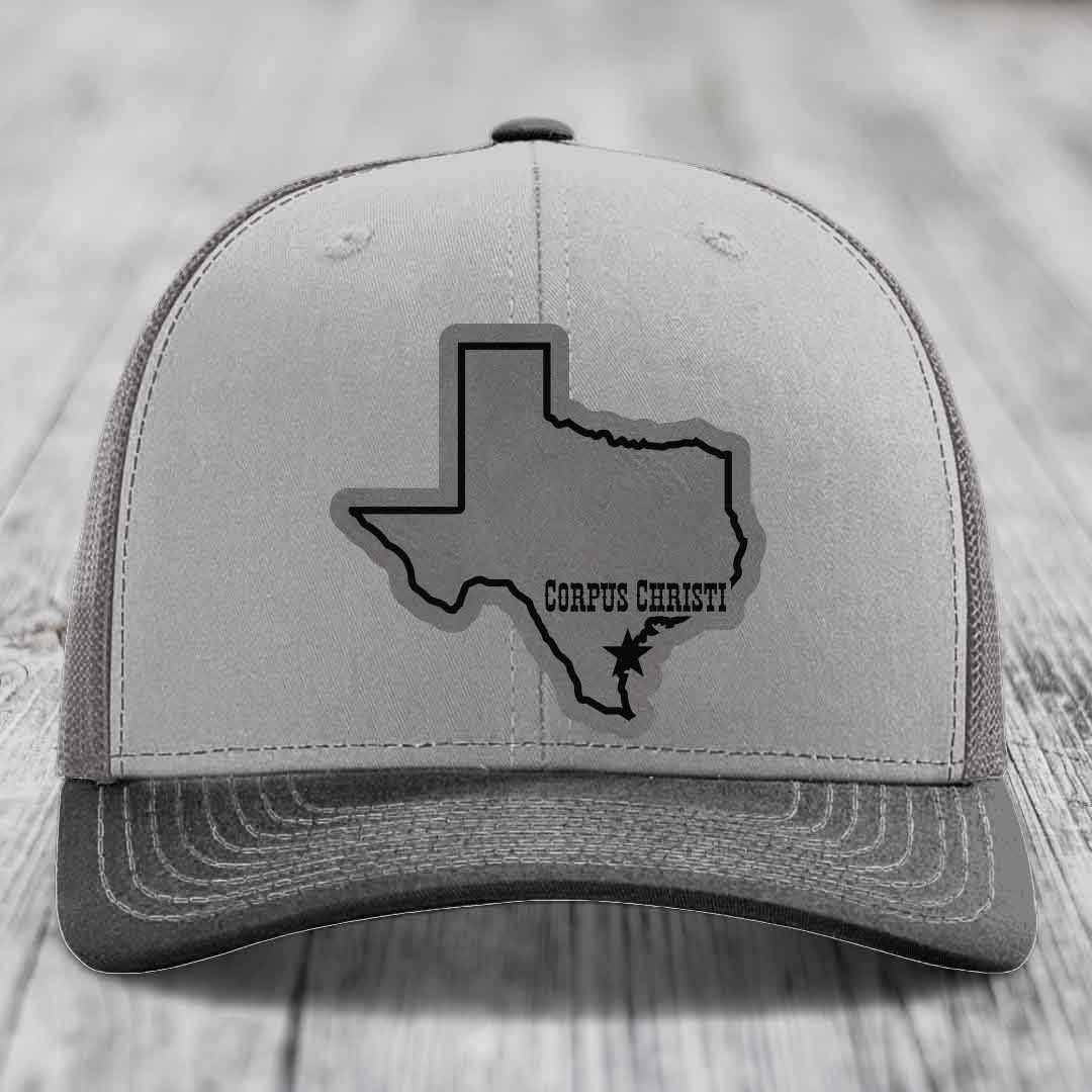 Grey and tan trucker hat with black Texas outline patch marked &