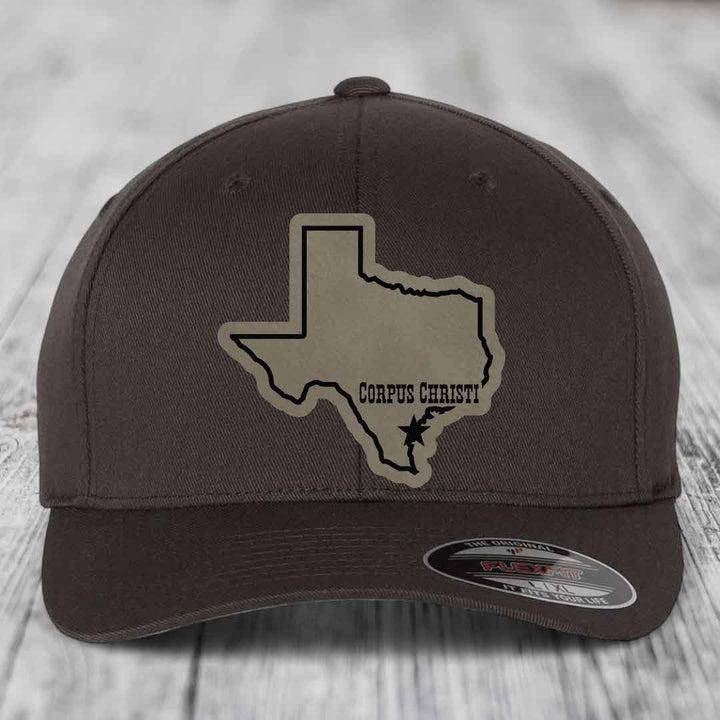 Brown baseball cap with tan Texas outline patch reading &