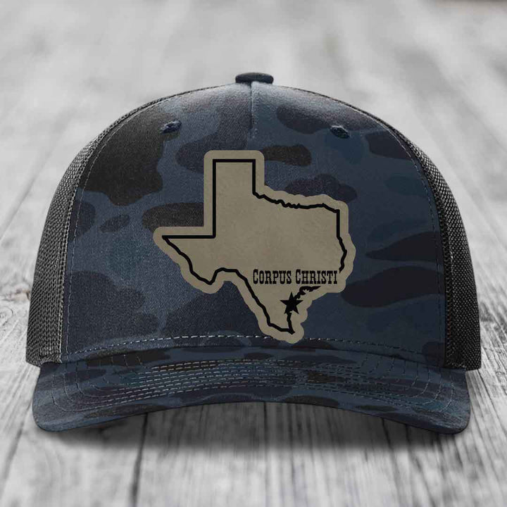 Camouflage trucker hat with Corpus Christi, Texas patch featuring state outline and star.
