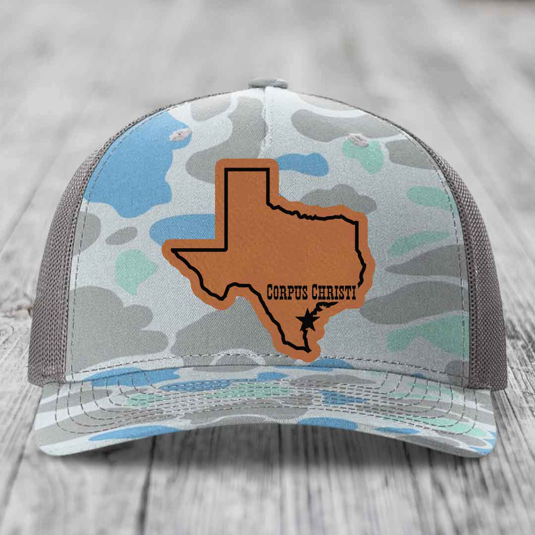 Camouflage trucker hat with gray Texas outline patch labeled &
