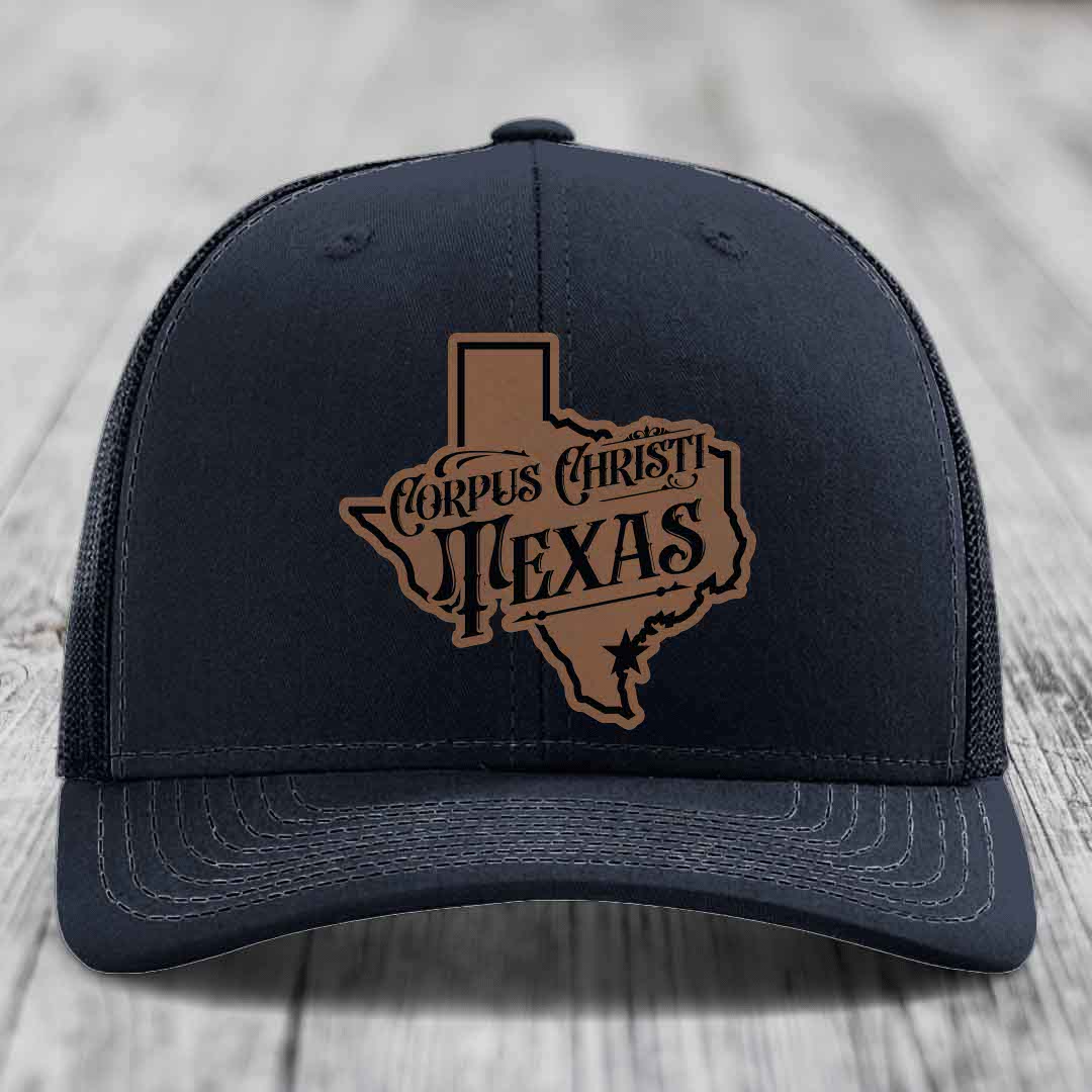 Purple trucker hat with brown leatherette patch shaped like Texas, reading &