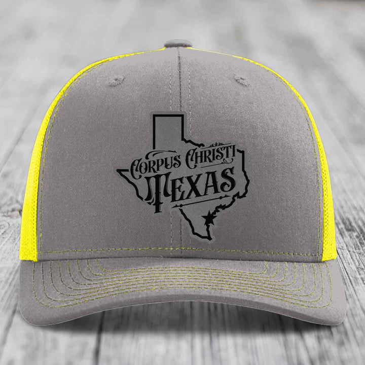 Brown trucker hat with gray Corpus Christi Texas patch on front, beige mesh back.