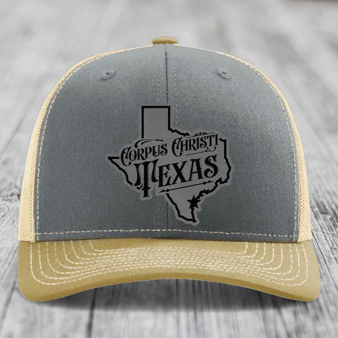 Grey trucker hat with black Corpus Christi Texas leather patch featuring state outline and star.