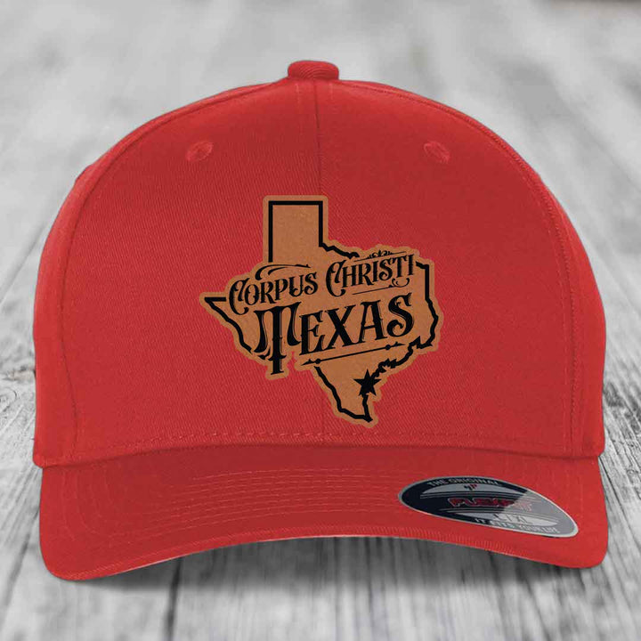 Red baseball cap with grey and black Corpus Christi, Texas patch on front.