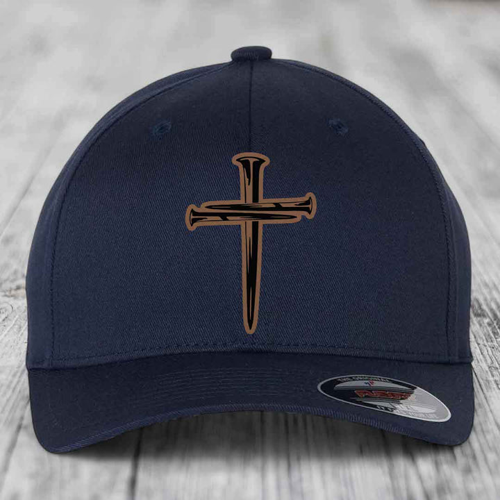 Dark blue baseball cap with a cross made of nails patch on front.