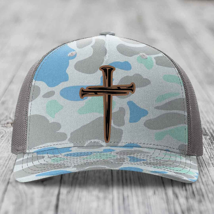 Black snapback hat with a cross made of nails patch on front.