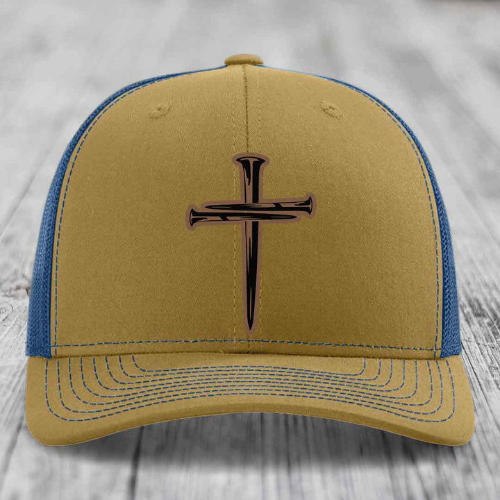 Black trucker hat with a brown cross of nails patch on the front.