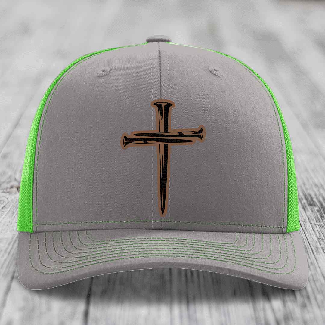 Grey trucker hat with orange mesh back and black cross of nails patch.