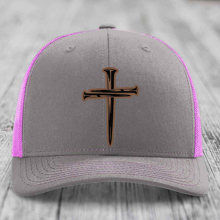 Grey trucker hat with yellow mesh and stitching, featuring a cross made of nails patch.