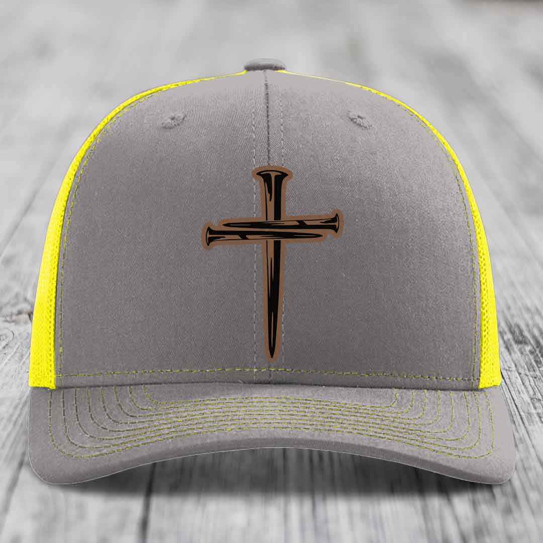 Brown trucker hat with a cross made of nails patch on front.