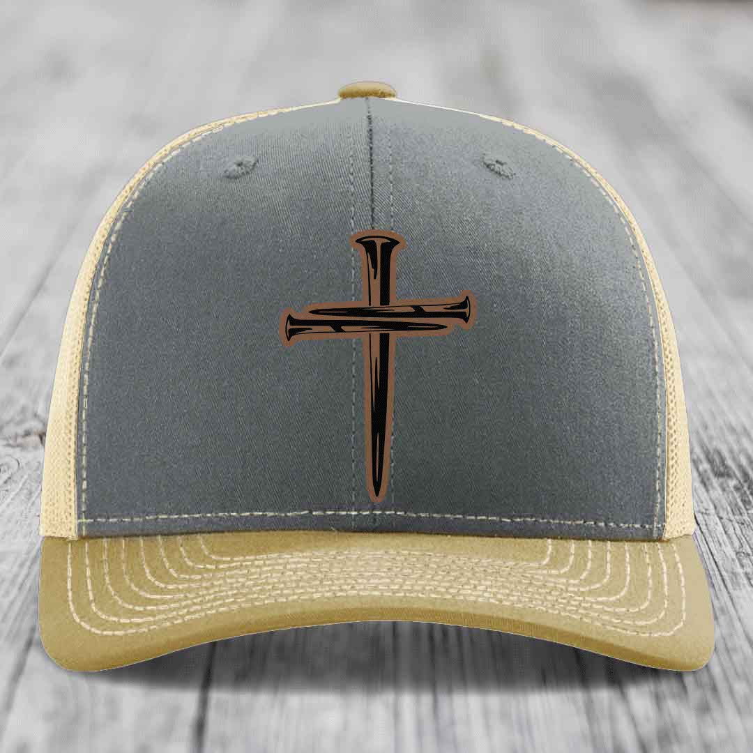 Grey trucker hat with a cross made of nails patch on front.