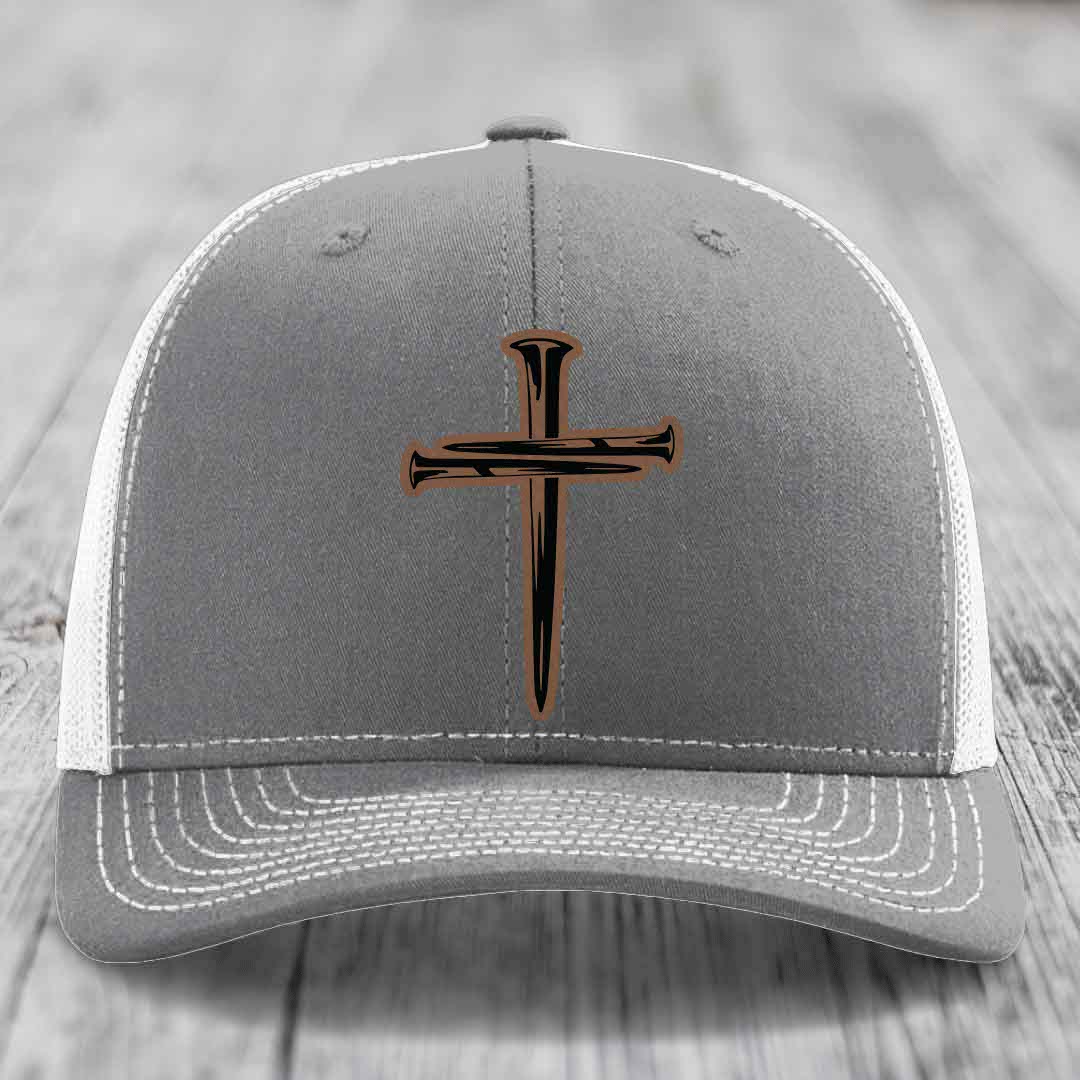 Pink trucker hat with black cross patch made of nails