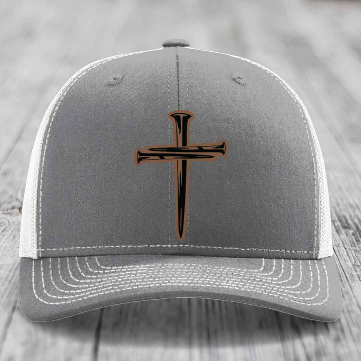 Pink trucker hat with black cross patch made of nails