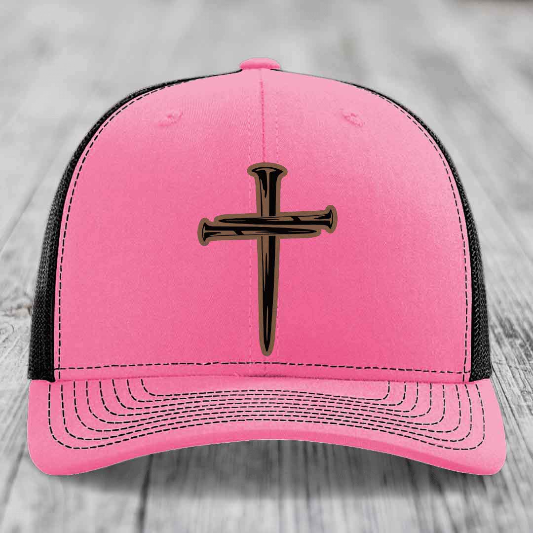 Green trucker hat with white mesh back and embroidered cross of nails patch.