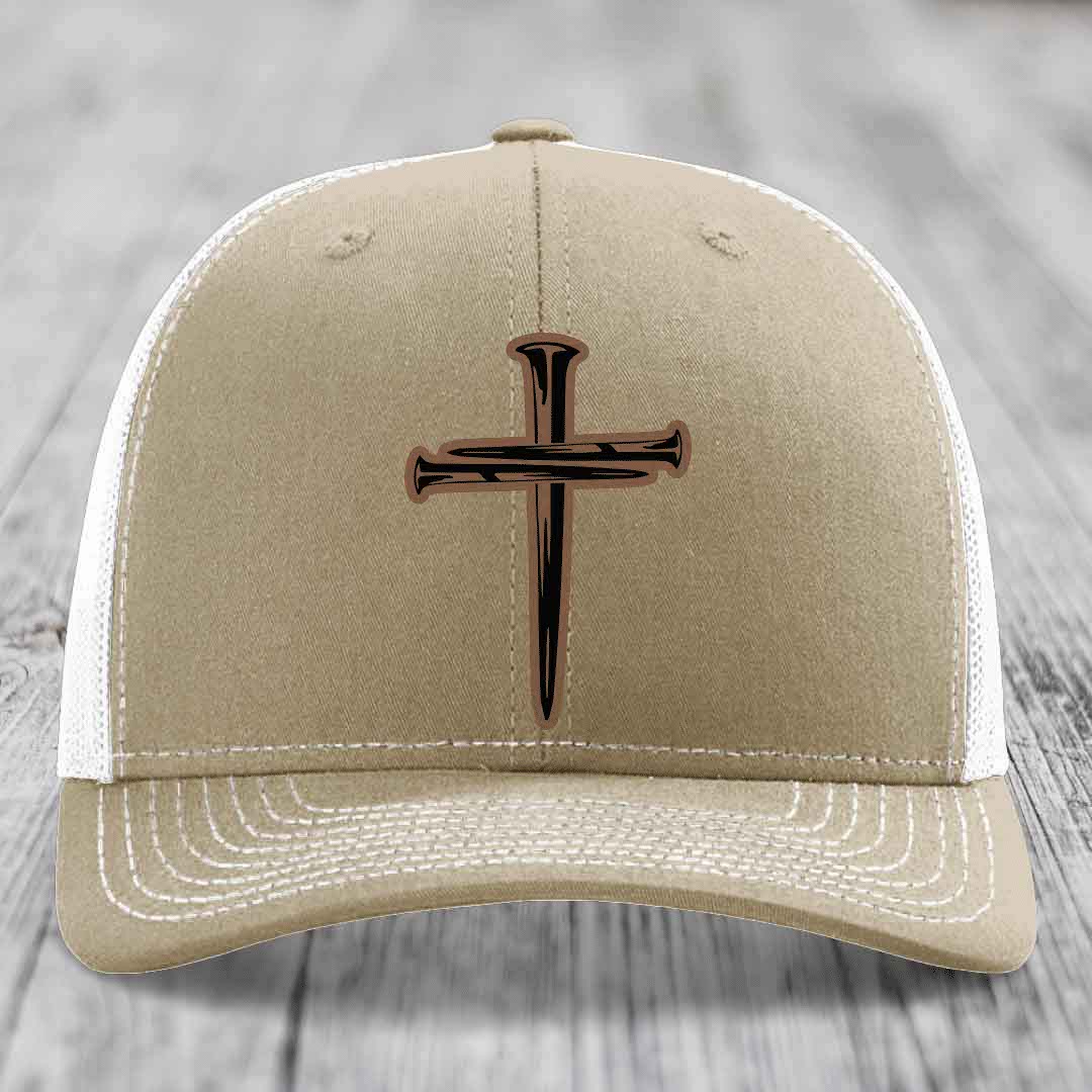 Olive green trucker hat with a cross made of nails patch on front.
