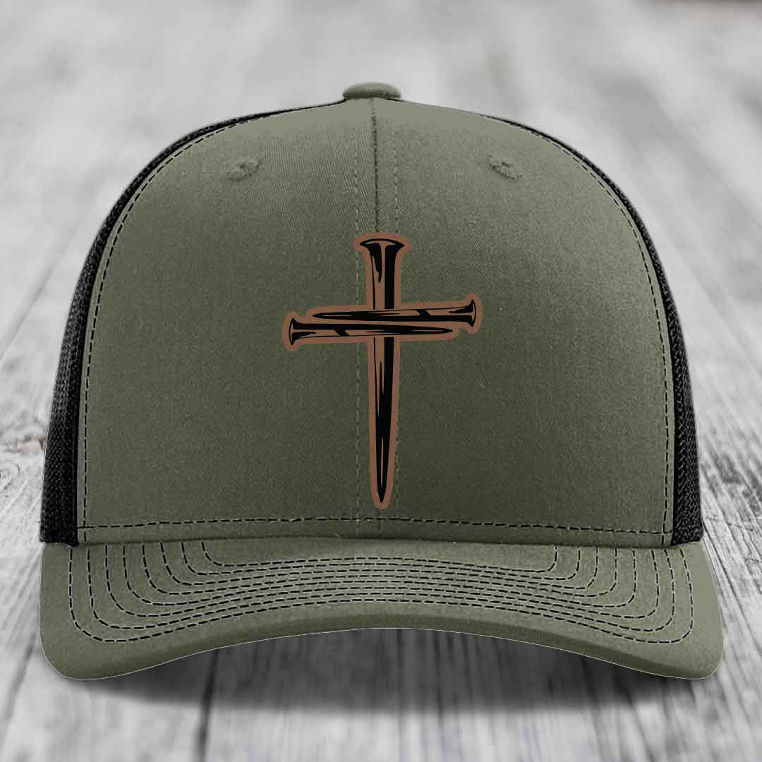 Black trucker hat with a brown cross of nails patch on front.