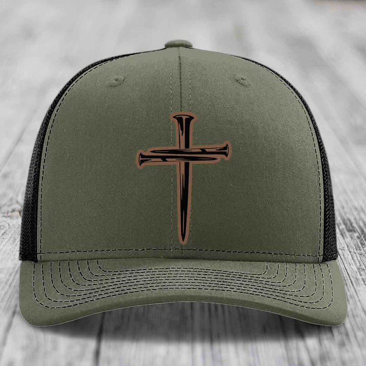 Black trucker hat with a brown cross of nails patch on front.