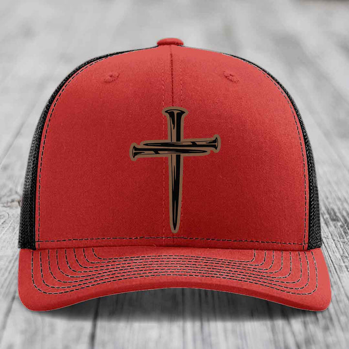 Blue trucker hat with a cross made of nails patch on front.