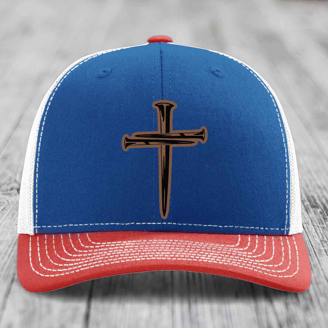 White trucker hat with a brown cross made of nails patch on front.