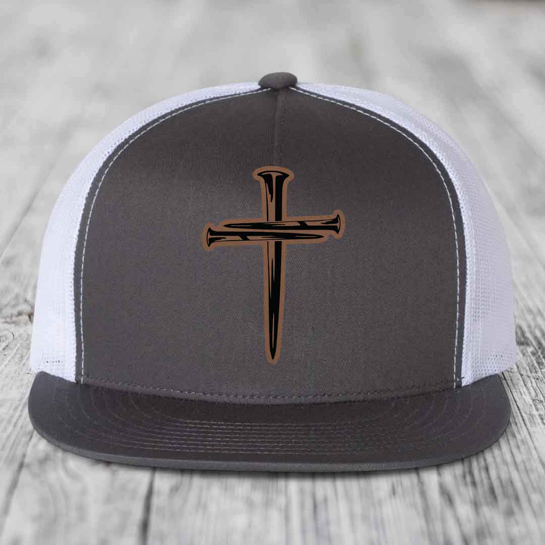 Red baseball cap with black and tan cross of nails patch on front.