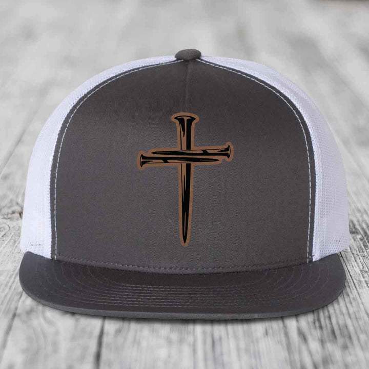 Red baseball cap with black and tan cross of nails patch on front.