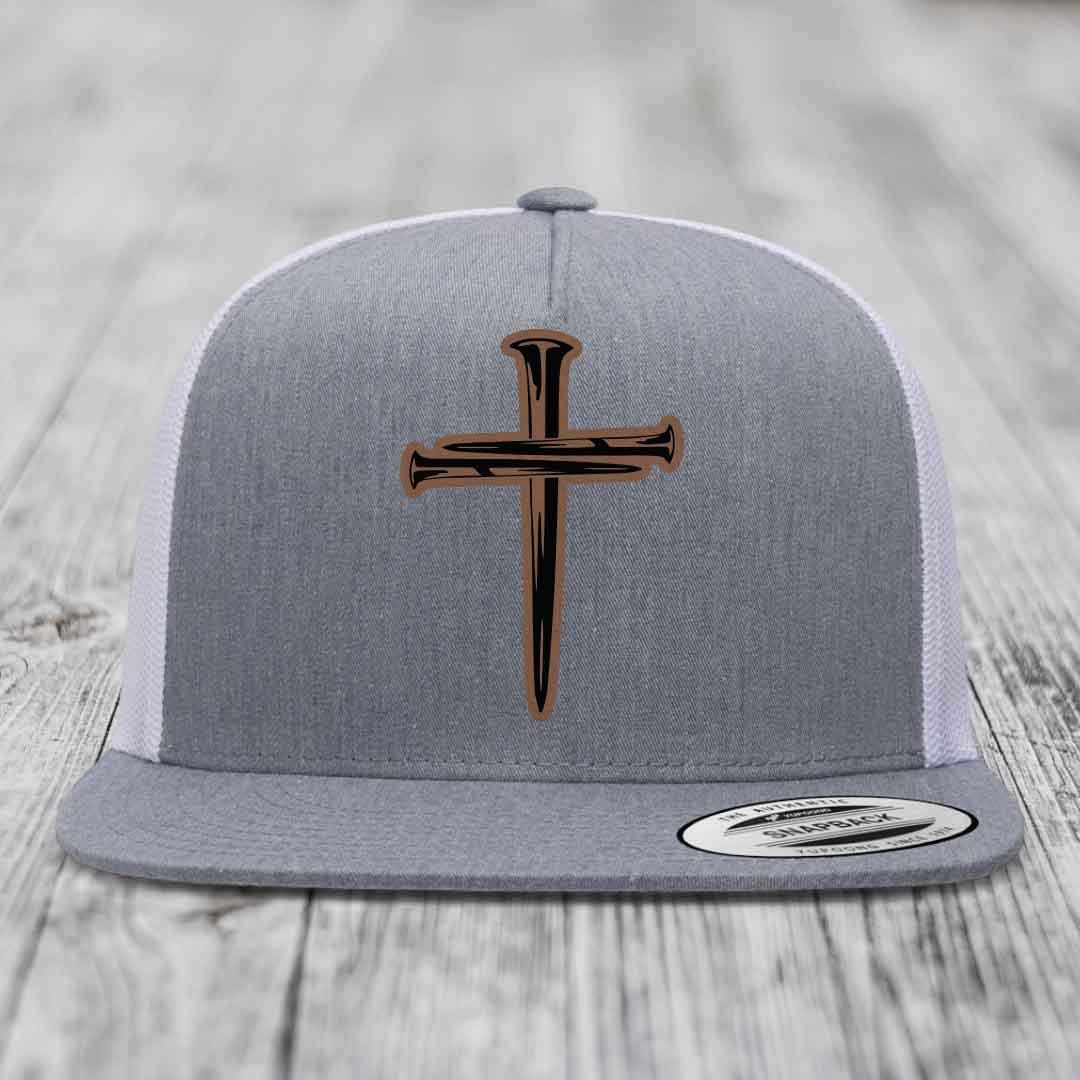 Grey front panel trucker hat with black and brown cross of nails patch.