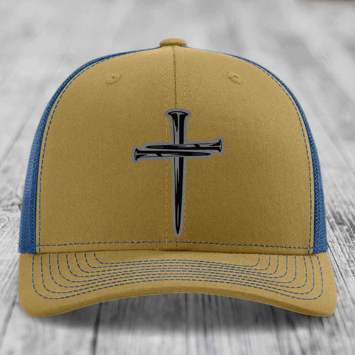 Black trucker hat with a silver cross made of nails embroidered on the front.