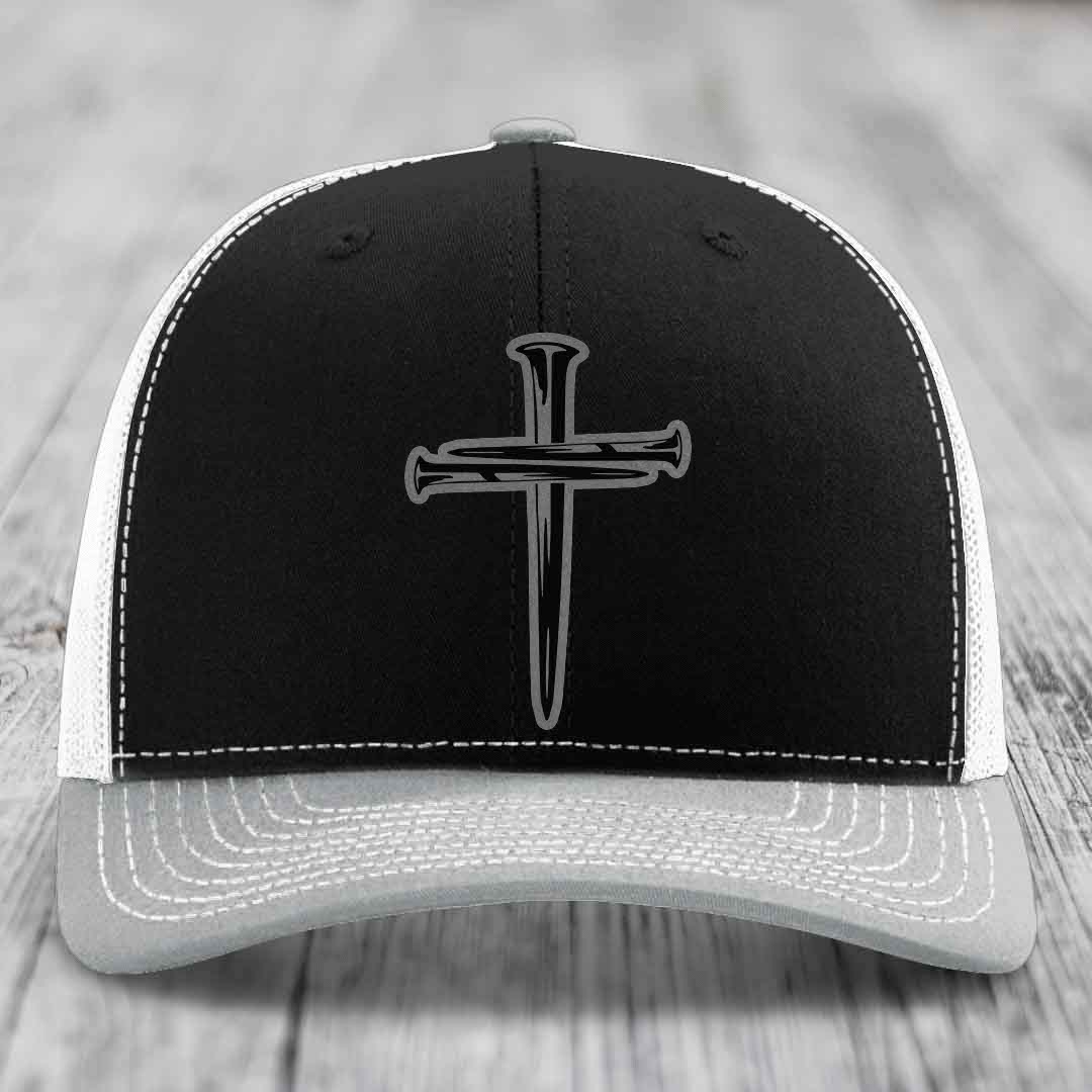 Brown trucker hat with white stitching and a cross made of nails patch on front.