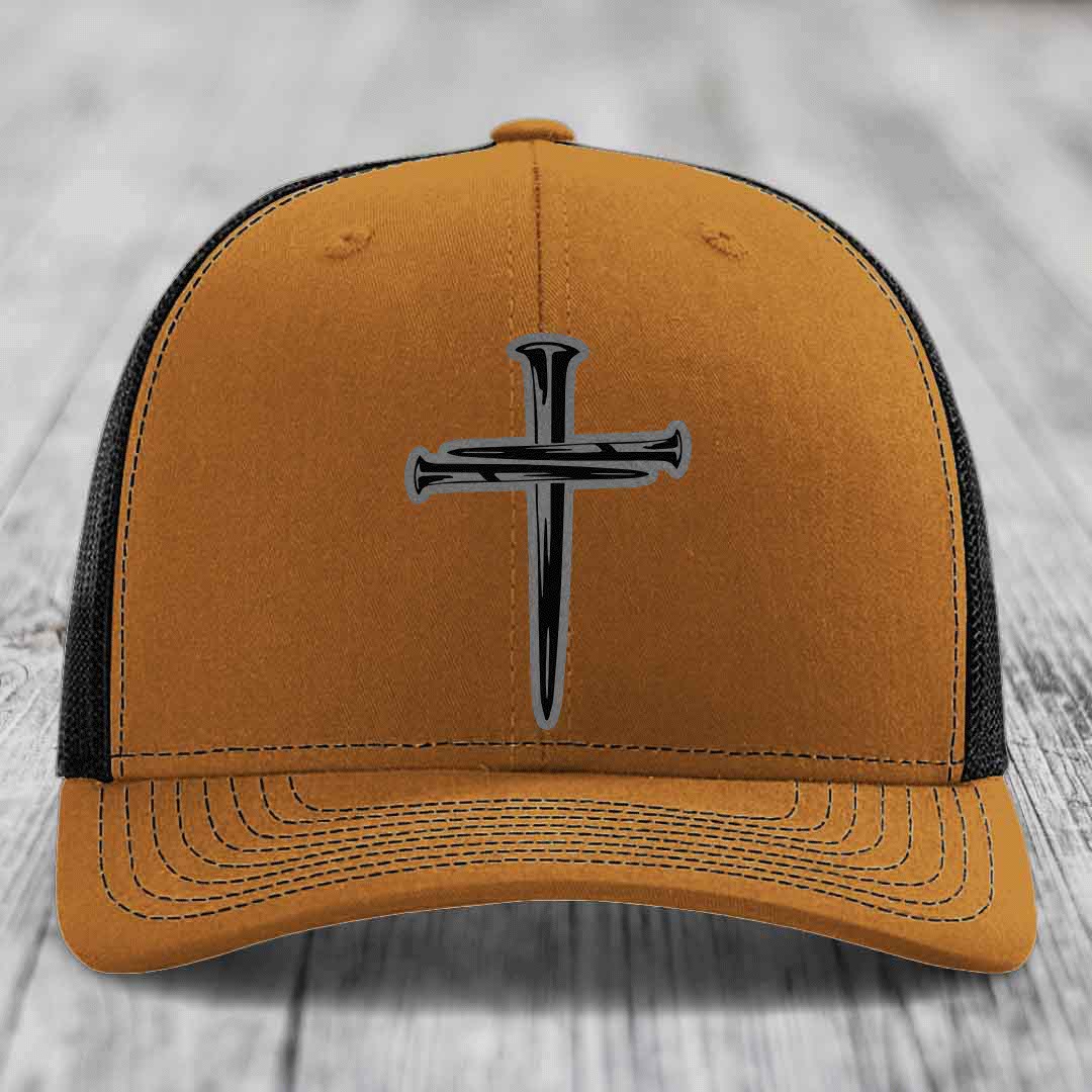 Grey trucker hat with black cross of nails patch on front, black mesh back.
