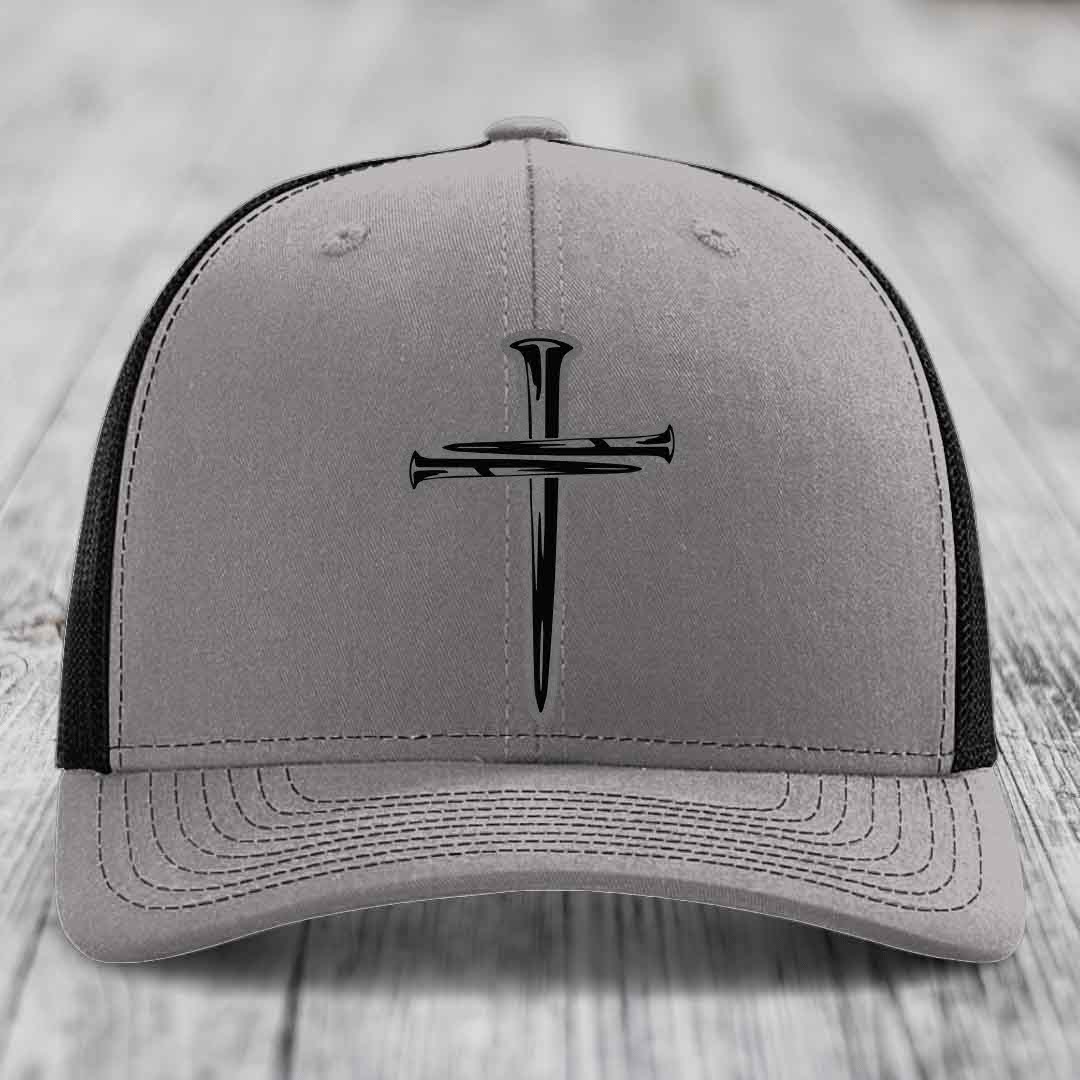 Grey trucker hat with black cross of nails patch and blue mesh sides.