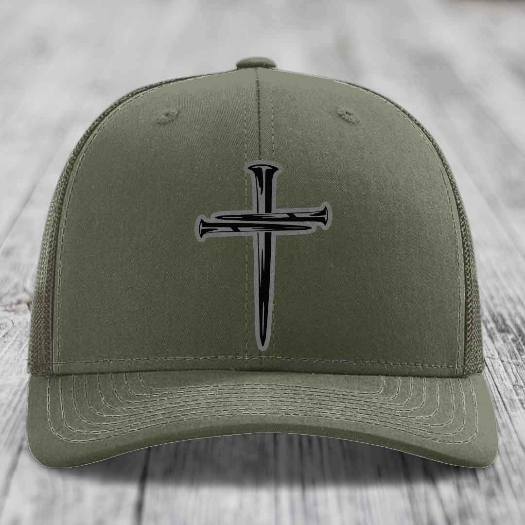 Olive green trucker hat with black cross of nails patch on front.