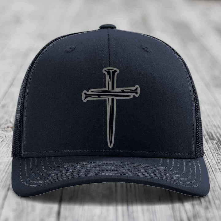 Purple baseball cap with black cross of nails patch on front, mesh back.
