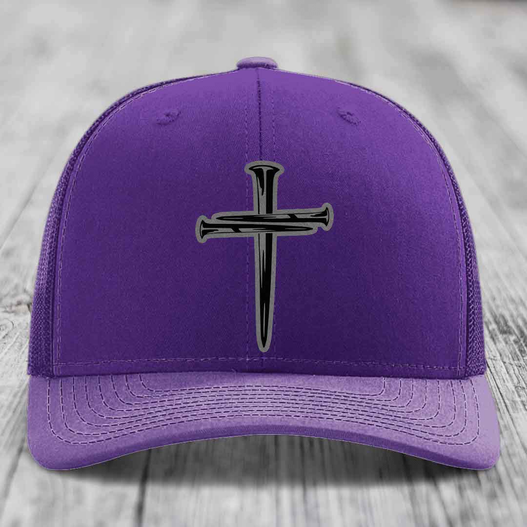Red trucker hat with black mesh back and gray cross of nails patch on front.