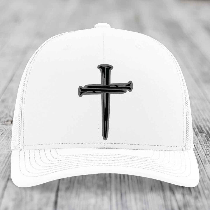 Black trucker hat with a cross made of nails patch on front.