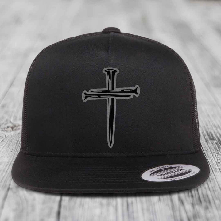 Black and white trucker hat with a cross made of nails patch on front.