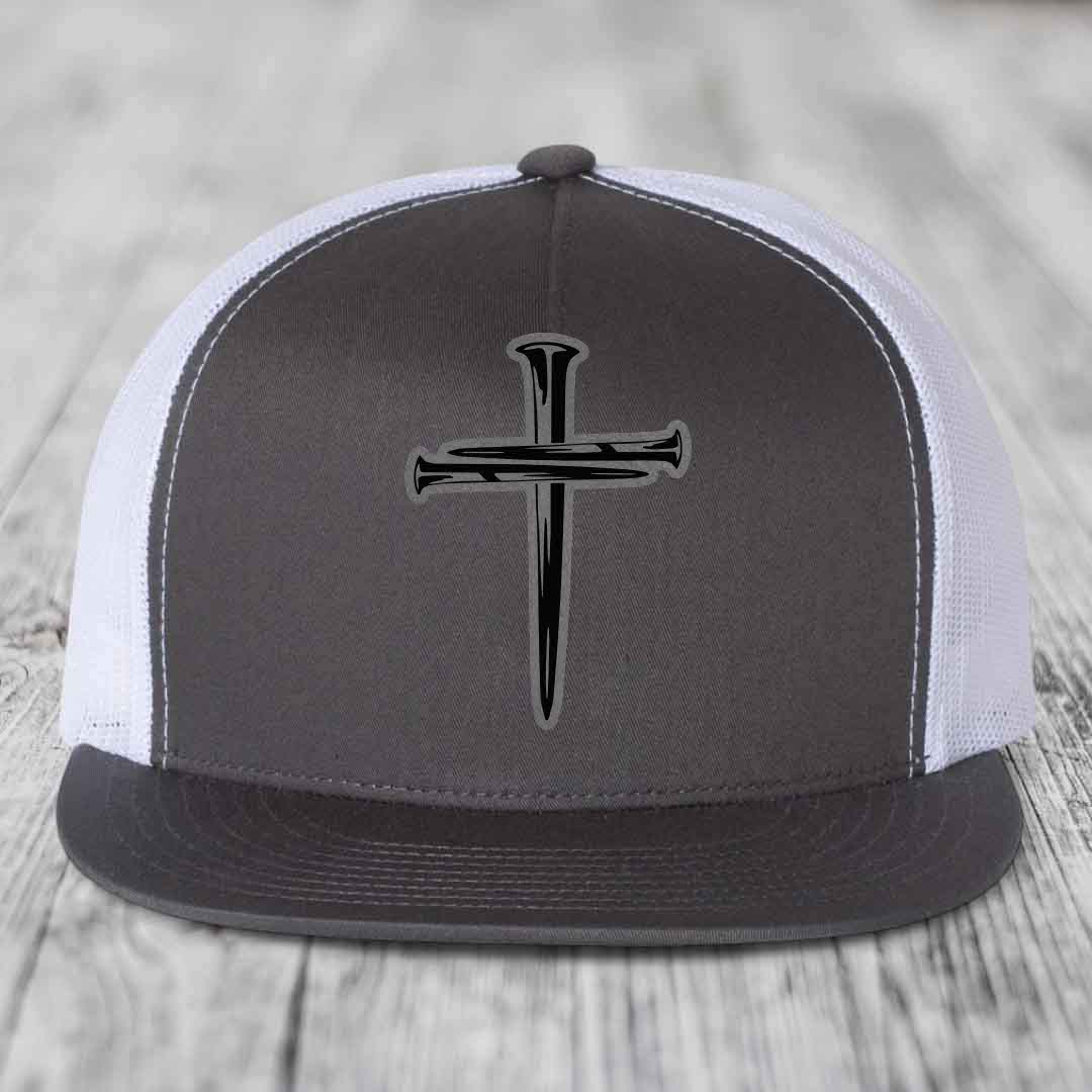 Black snapback hat with a cross made of nails patch on front.