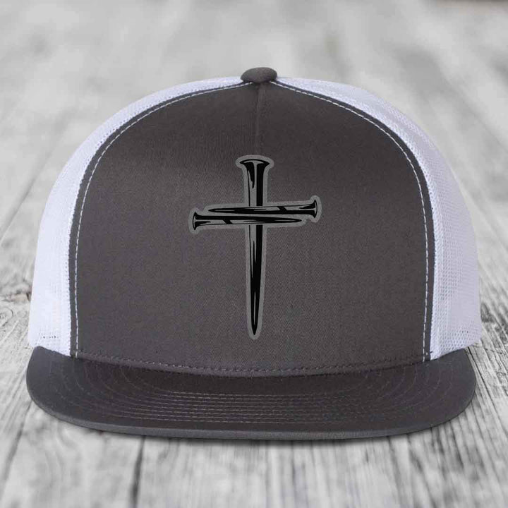 Black snapback hat with a cross made of nails patch on front.