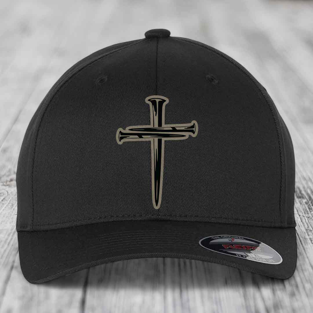 Tan baseball cap with black cross of nails patch on front, Flexfit label visible.