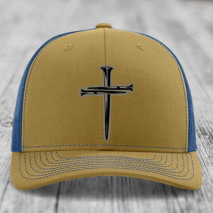 Black trucker hat with a cross made of nails patch on front.
