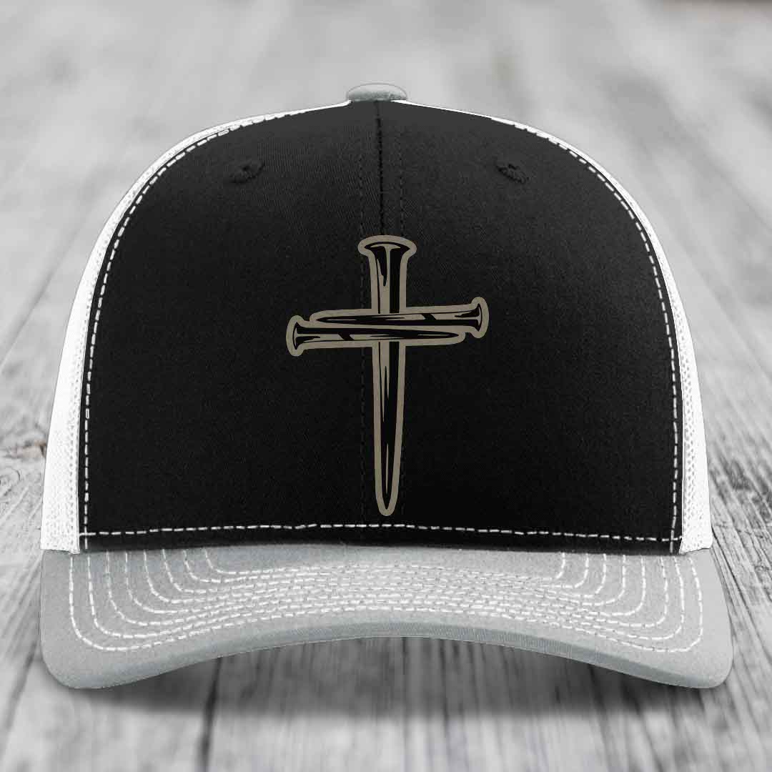Brown trucker hat with white stitching and a cross made of nails patch on front.