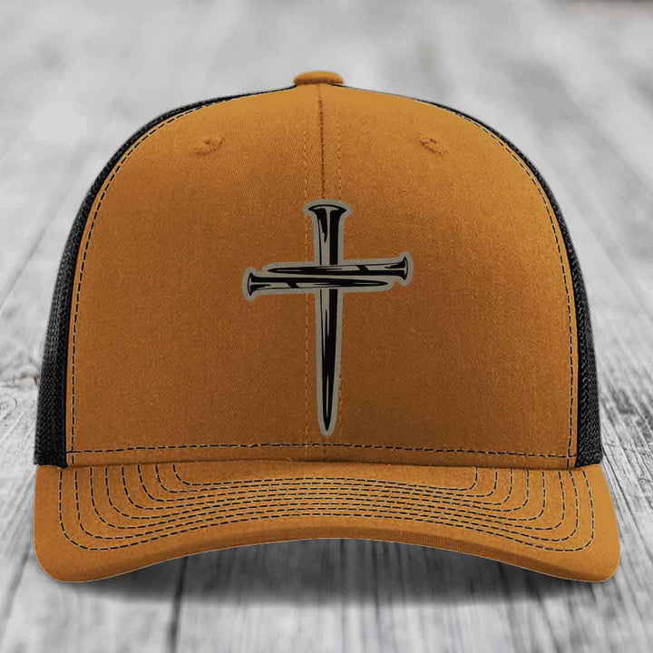 Grey trucker hat with black cross of nails patch on front.