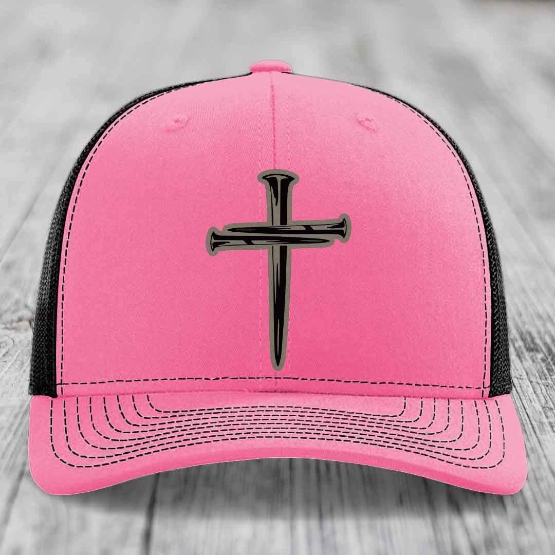 Green trucker hat with white mesh back and embroidered cross of nails patch.