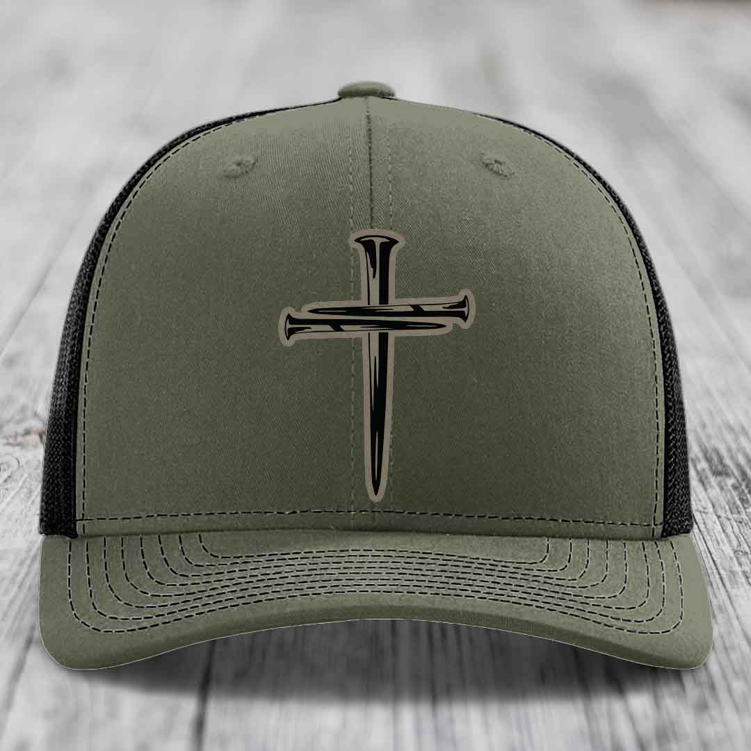 Black trucker hat with a beige cross made of nails patch on front.