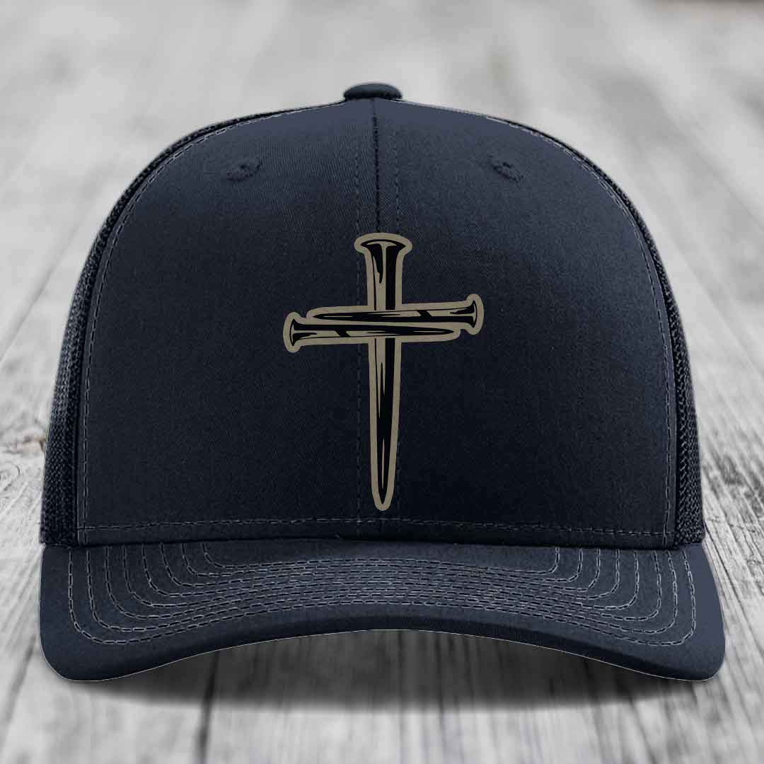 Purple baseball cap with a black cross and nail patch on front, mesh back, stitched brim.