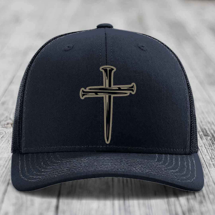 Purple baseball cap with a black cross and nail patch on front, mesh back, stitched brim.